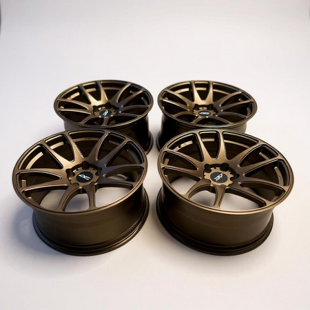 Four bronze alloy wheels on a white background