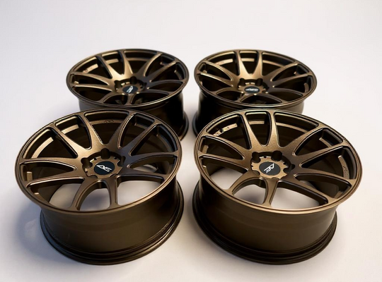 Four bronze alloy wheels on a white background